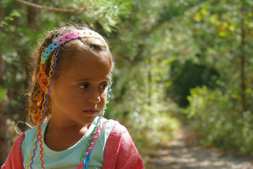 close up of a little girl with baby extension in the woods