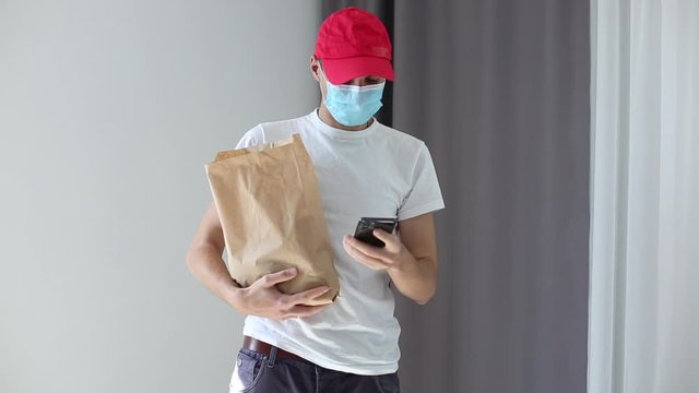 Delivery Man In Protective Mask Holding Takeout Bag