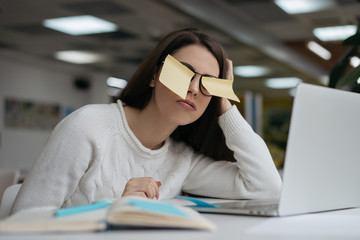 Portrait of busy freelancer working project, using sticky notes for productivity. Tired student studying, exam preparation. Unhappy woman sleeping at workplace, overwork concept