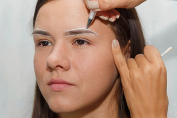 Naklejka premium The wizard creates the contour of the clients eyebrows before the procedure.