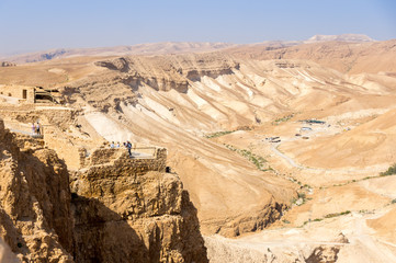 Tourists look at the mound of the Romans to capture the fortress of Masada, Israel
