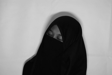 Close up view of Pretty lady woman girl wear hijab jilbab niqab kerudung niqaab scarf cover face and only show visible look of her beauty eyes. Fit for put design life image. Black white  with grain t
