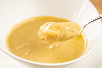 Cream-soup with porcini mushroom with croutons on wooden table. Restaurant menu