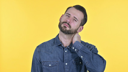 Fototapeta premium Portrait of Tired Young Man having Neck Pain, Yellow Background