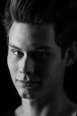 Portrait of a young handsome dark haired man with a fan