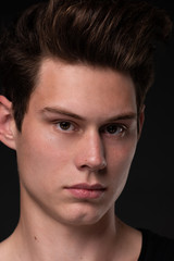 Obraz premium Portrait of a young handsome dark haired man with a fan