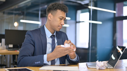 Disappointed Young Businessman Trying to Write on Paper