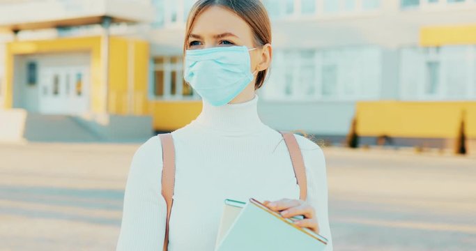 Woman In A Protective Sterile Medical Mask On Her Face, Looks At The Camera In The Open Air, Shows A Palm, A Hand, A Stop Sign, A Stop Without A Sign. The Concept Of The Chinese Pandemic Of The Virus.