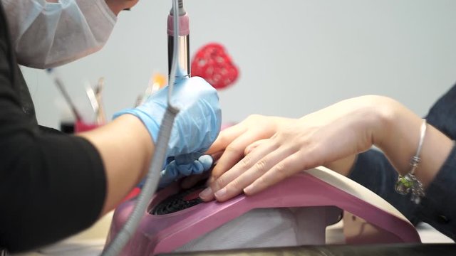 Manicurist polishes the nails of the client