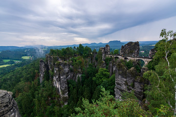 Fototapeta na wymiar Famous bridge Basteibruecke in Saxon Switzerland on a cloudy day