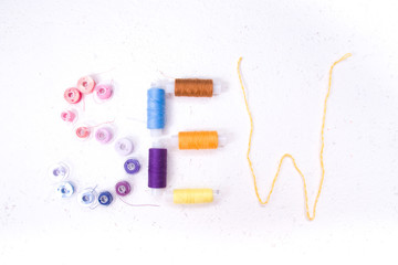 inscription sew from various accessories for needlework, spools of thread, thread, white background, copy space