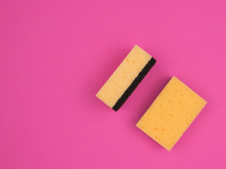 Accessories for washing dishes on a pink background.