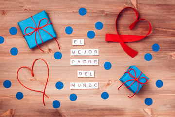 El mejor papa del mundo words made of wooden blocks with blue gift boxes and red hearts on wooden...