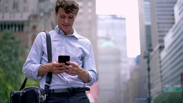 Young guy checking financial news on website connected to 4g wireless for surfing internet outdoors, Caucasian man with briefcase reading received email from partner