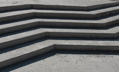 concrete curvilinear steps without a ramp. The falling shadow from a product from concrete in the form of a zigzag