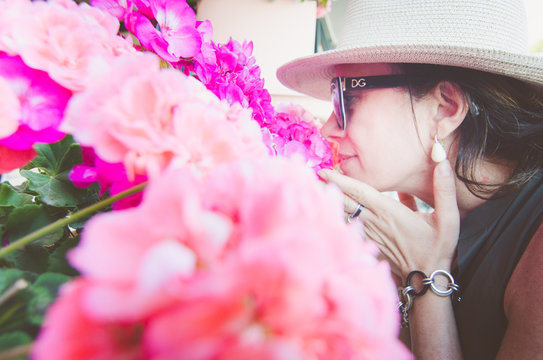 Close-up Of Mature Woman Smelling Pink Flowers