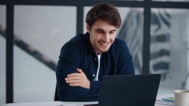 Smiling businessman getting good news on email. Cheerful guy working laptop