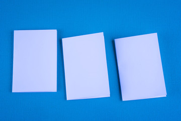 Blank portrait mock-up paper. brochure magazine isolated on blue, changeable background / white paper isolated on light blue paper.
