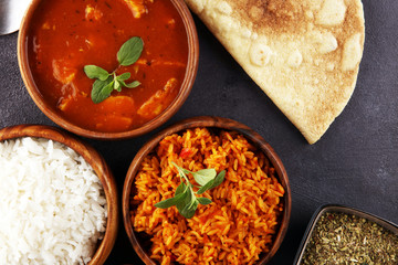 Chicken tikka masala spicy curry meat food in pot with rice and naan bread. indian food on table
