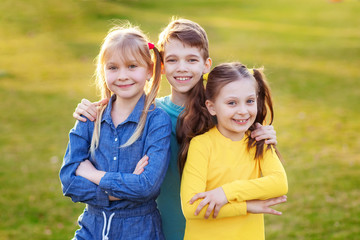 Happy children play and relax in the summer park.