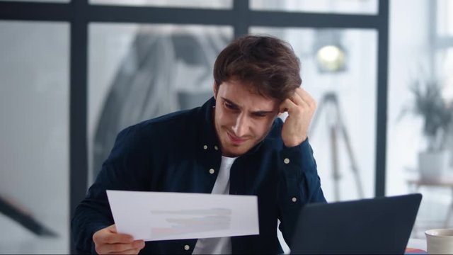 Shocked businessman finding mistakes in documents. Upset man getting bad results