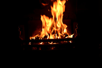 Dancing flames of a Festive log fire. Hot red charcoal in black background