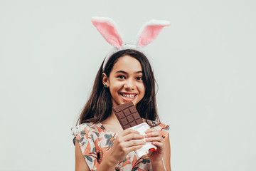 Portrait of happy little girl celebrating easter eating chocolate