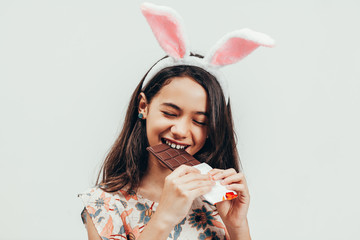 Portrait of happy little girl celebrating easter eating chocolate