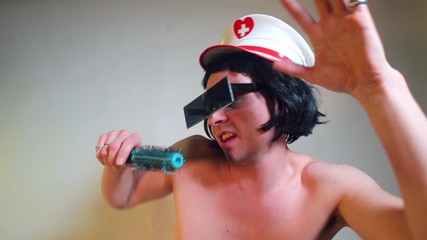 Rock star in a cap and black glasses sings a song into the microphone. Makes sharp dance moves with his hands. The concept of shocking behavior.