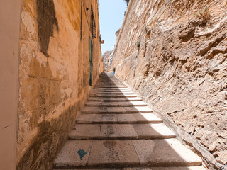 Coast of Valletta, Malta. You can see old streets with long stairs and the Mediterranean Sea in the background.