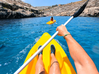 Tourists practicing kayaking on one of the beaches on the island of Gozo, Malta. People enjoying...
