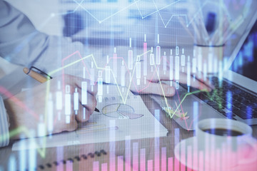 Multi exposure of stock market graph with man working on laptop on background. Concept of financial analysis.