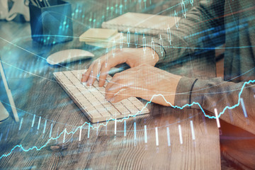 Multi exposure of financial graph with man works in office on background. Concept of analysis.