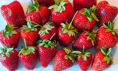 Background of fresh strawberries with leaves.