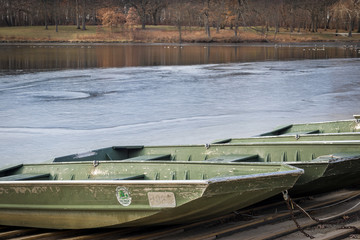 Fishing boats are pulled up onto the shore of a small lake as ice forms, signalling the end of the summer recreation season.