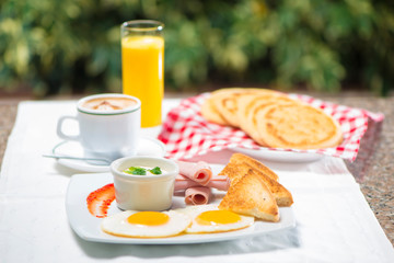 Desayuno Continental huevos pan jamon y crema con café y jugo de naranja 