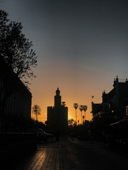 Urban view of Seville in an orange sunset. Gold tower.