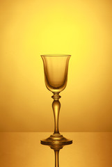 Empty wine glass on a yellow background