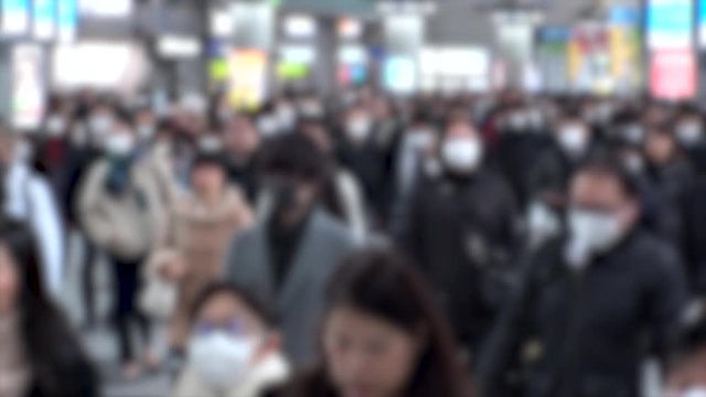 TOKYO, JAPAN - MARCH 2020 : Crowd of people walking at Shinagawa station in morning rush hour. Commuters going to work. People wearing mask to protect from Coronavirus(COVID-19). Blurred slow motion.