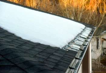 Snow melting on shingled roof with eavestrough drain