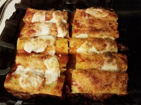 Hot Baked Stuffed Manicotti Pasta In Glass Bowl On Stove