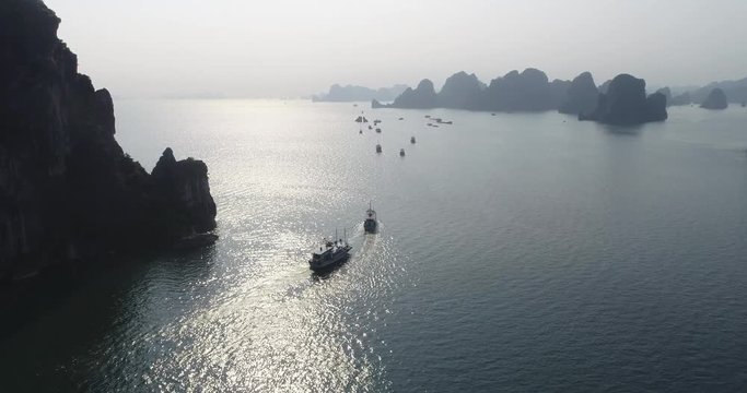 Aerial view of royalty high quality free stock footage over natural rocks green tops Halong bay, Ba Hang floating fishing village, sea blue azure water. Wild natural untouched seascape. Asia, Vietnam