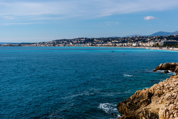 The panoramic view of the Mediterranean Sea with the landscape of city of Nice on the horizon and coastline cliffs on a sunny day (Provence Côte d'Azur, France)