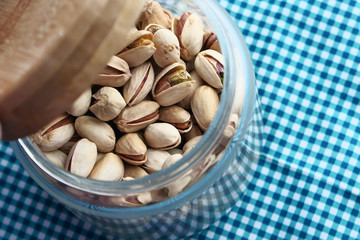 Close up of pistachios in a jar on table