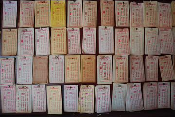 Pray and draw divination sticks at a temple, with the unsign answer paper on the wall.