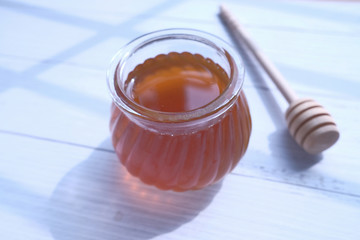 close up of honey in a jar on white table 