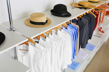Stylish clothes with hats in modern store