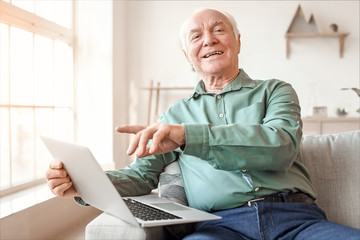 Elderly man with laptop at home