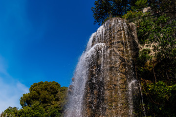 The view of the man-made waterfall on the touristic Castle Hill of Nice, France on a sunny day