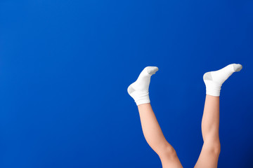 Plakat Legs of little girl in socks on color background